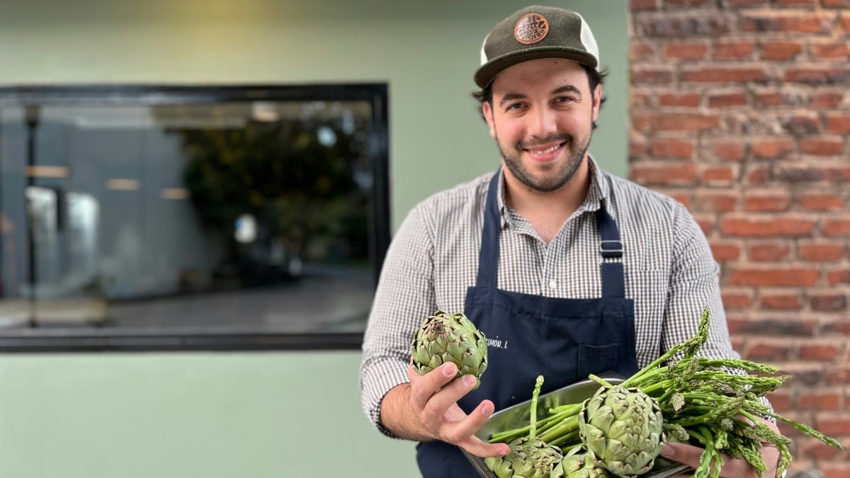 Simón Lochbaum, cocinero de Marga, sostiene alcauciles y espárragos de estación.
